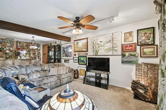 a living room with furniture a flat screen tv and a floor to ceiling window
