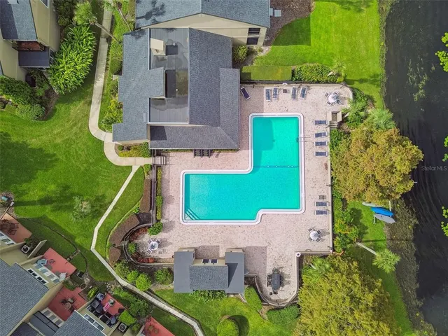 an aerial view of a house with garden space ocean and trees