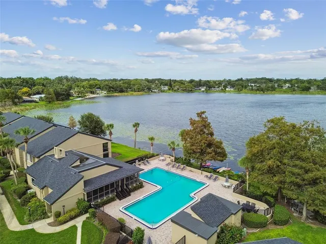 an aerial view of a house with outdoor space and lake view in back