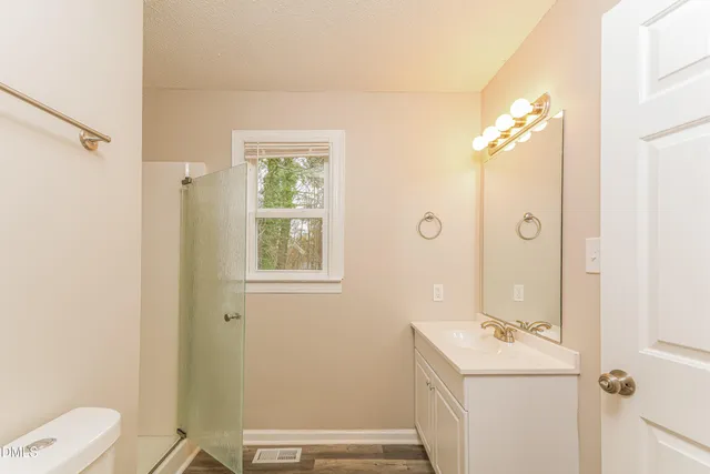 a bathroom with a sink a toilet and shower