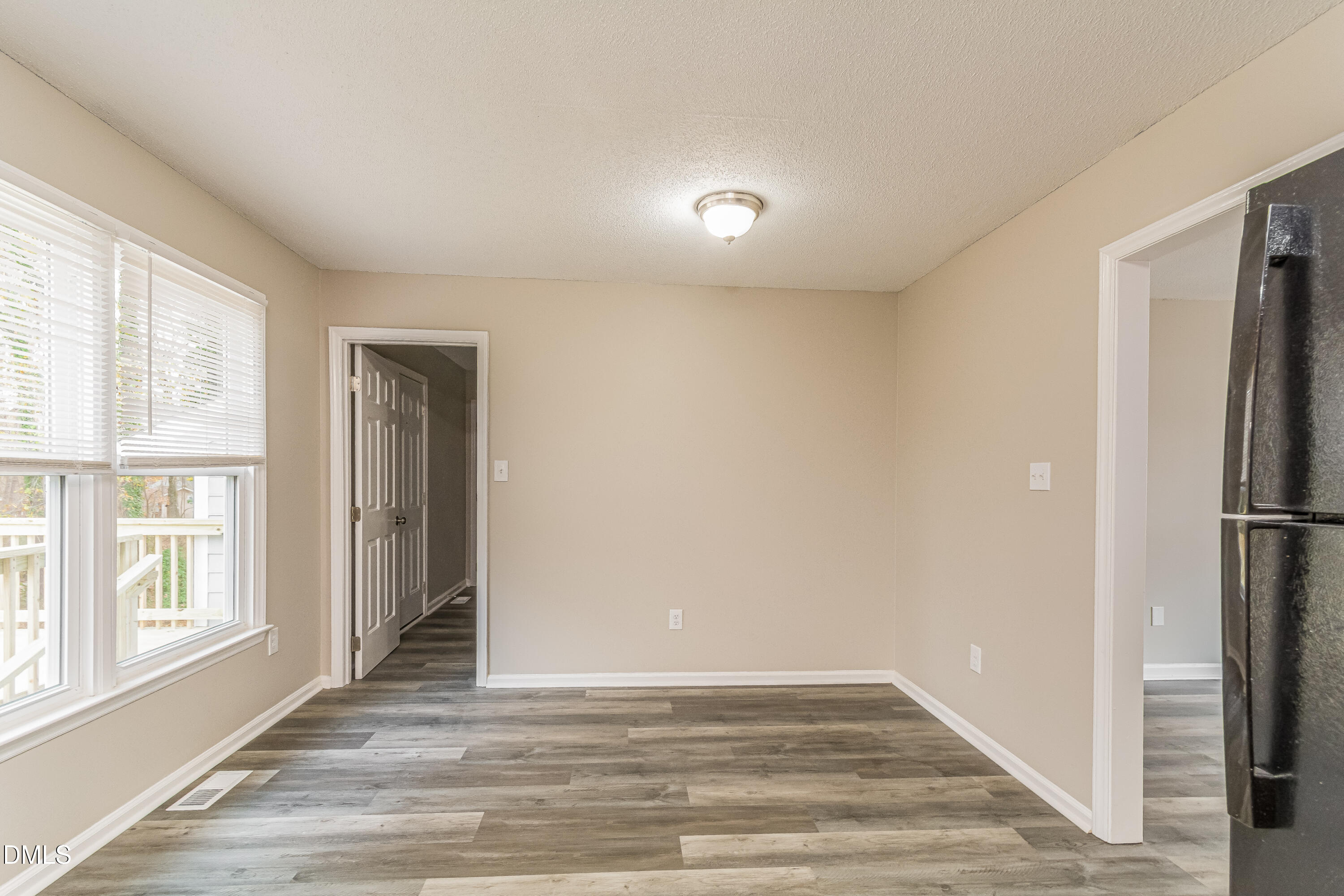 617 Bartlett Road Fuquay-Varina, NC 27526 - Photo 4 of 16 a view of an empty room with wooden floor and a window