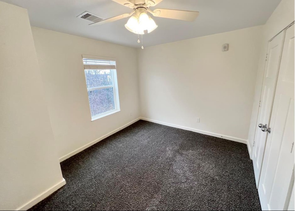 21155 Gosling Road, Unit 47B Spring, TX 77388 - Photo 23 of 29 an empty room with a chandelier fan and windows