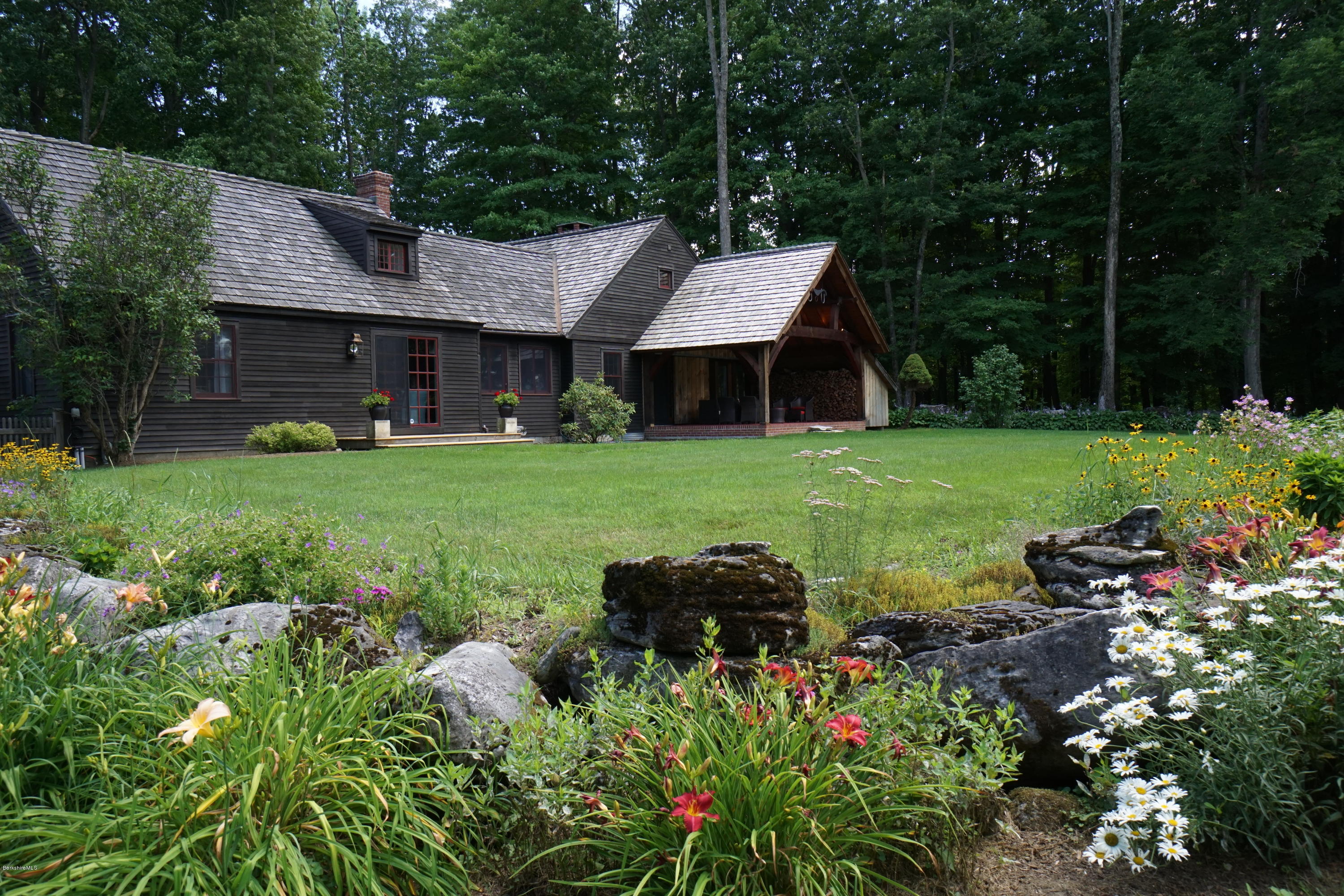 a backyard of a house with table and chairs and potted plants