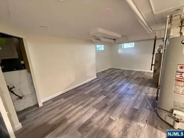 a view of empty room with wooden floor and window