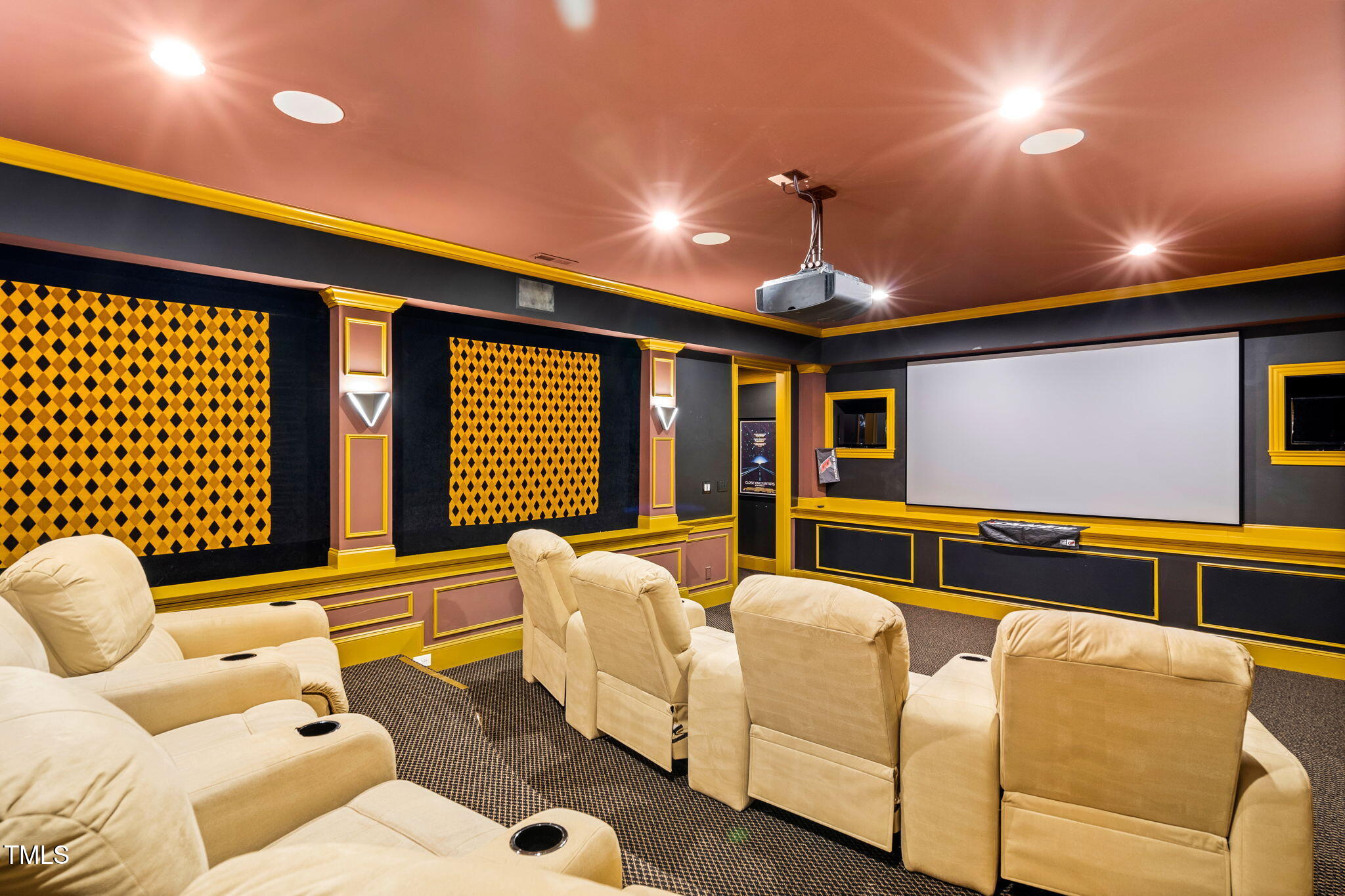 11201 Jonas Ridge Lane Raleigh, NC 27613 - Photo 61 of 79 Theater room featuring a ramped hallway with a lighted handrail, leading to unique tri-level seating with custom reclining chairs
• Updated (2022) 135” Gold LCR screen with upgraded projector, flanked by TVs for monitoring house cameras or watching TV; includes surround sound, fabric-upholstered walls, and sconce lighting