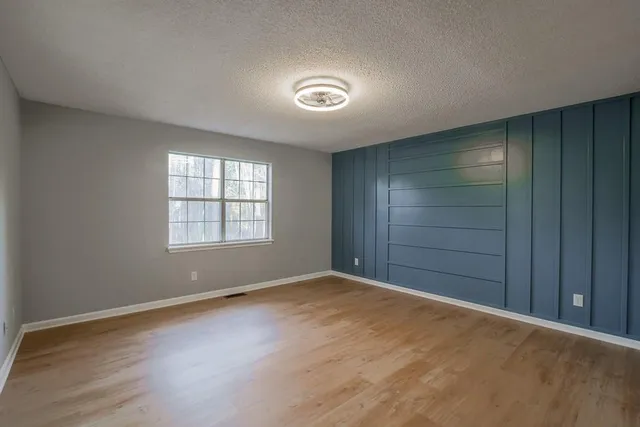 an empty room with windows and closet