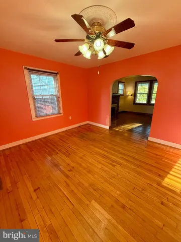 a view of an empty room with window and wooden floor