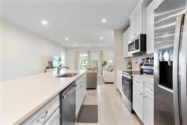 a kitchen with white cabinets sink and stainless steel appliances