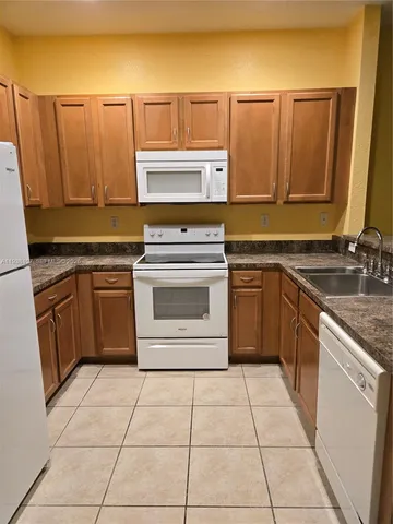 a kitchen with a stove top oven sink and cabinets