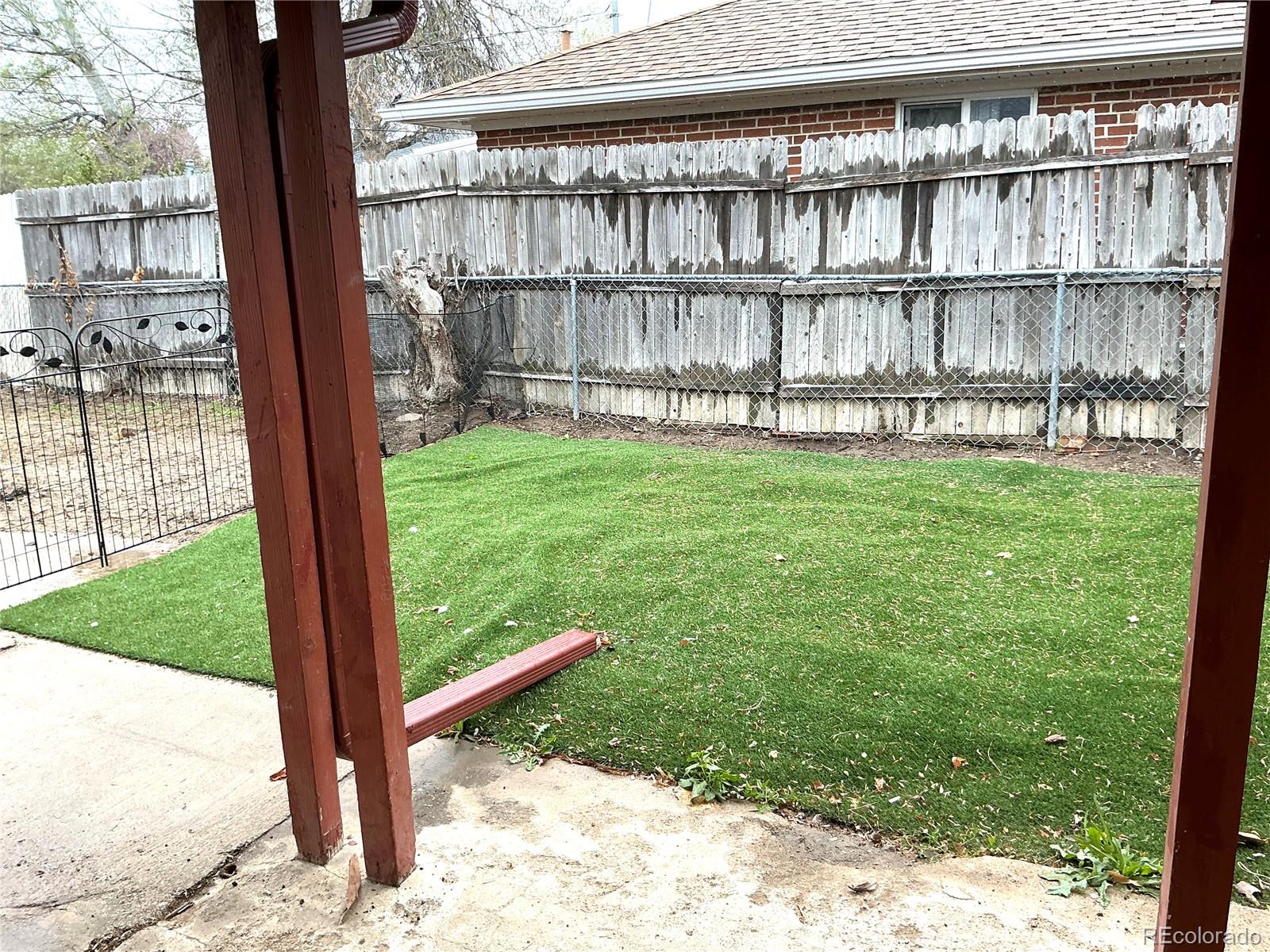 Undisclosed Address Aurora, CO 80010 - Photo 19 of 23 a view of a yard with a fence and a tree