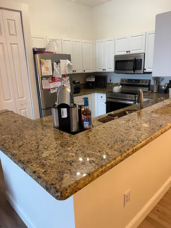 a kitchen with stainless steel appliances granite countertop a sink stove and microwave