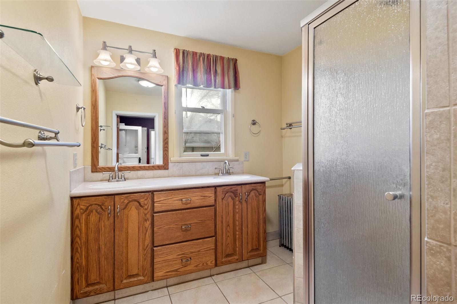 303 South 3rd Street Sterling, CO 80751 - Photo 18 of 50 a spacious bathroom with a granite countertop sink a mirror and a shower