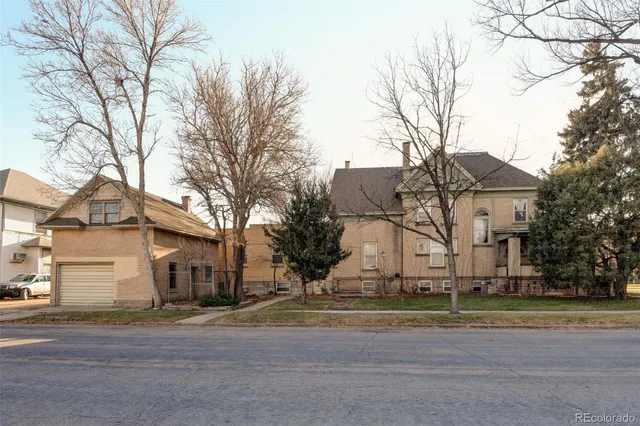 a view of a white house with a road and a trees