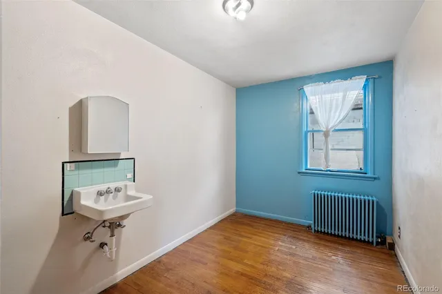 a view of a hallway with wooden floor and a living room