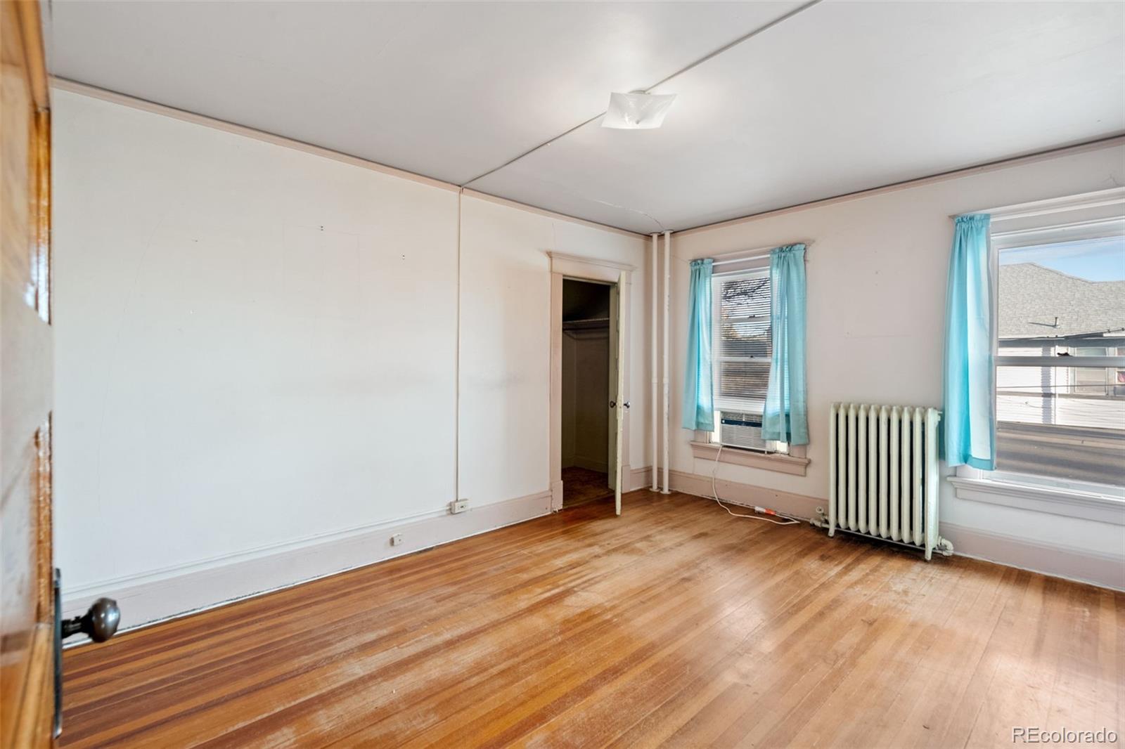 303 South 3rd Street Sterling, CO 80751 - Photo 35 of 50 an empty room with wooden floor and windows