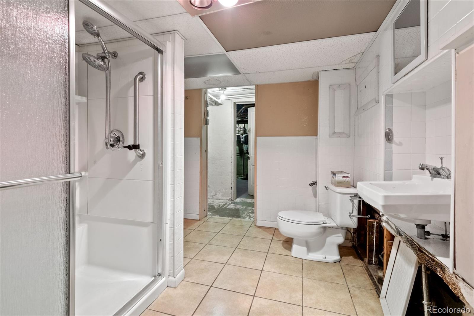 303 South 3rd Street Sterling, CO 80751 - Photo 43 of 50 a bathroom with a sink a toilet a mirror and shower