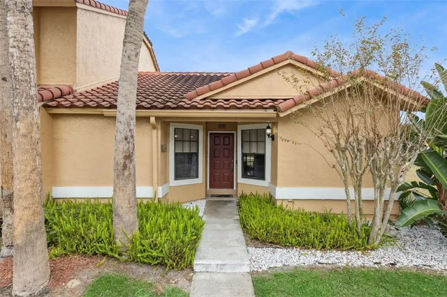 a view of a house with brick walls and a yard with plants