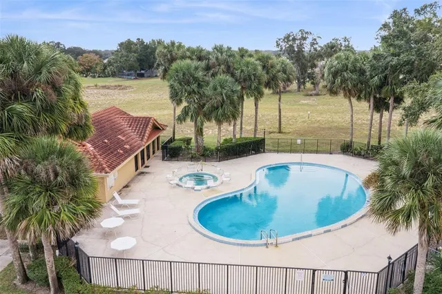 a view of a swimming pool with a garden and trees