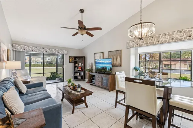 a living room with furniture a flat screen tv and a large window