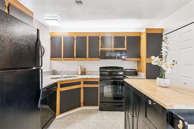 a kitchen with stainless steel appliances granite countertop a stove a sink and a refrigerator