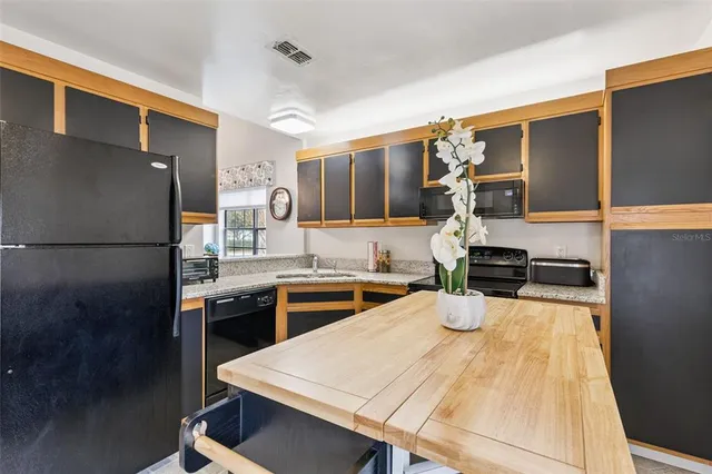 a kitchen with a refrigerator a stove and a sink with wooden floor