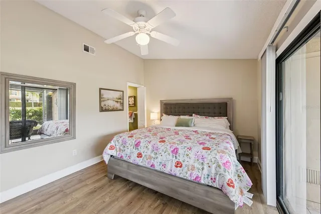 a bedroom with a bed a window and painting on the wall