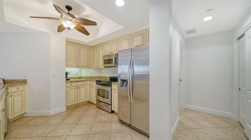 14041 Bellagio Way, Unit 316 Osprey, FL 34229 - Photo 21 of 74 a kitchen with stainless steel appliances granite countertop a refrigerator a stove a sink and dishwasher