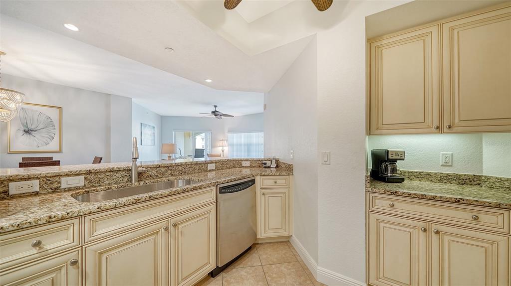 14041 Bellagio Way, Unit 316 Osprey, FL 34229 - Photo 23 of 74 a kitchen with granite countertop a sink and cabinets