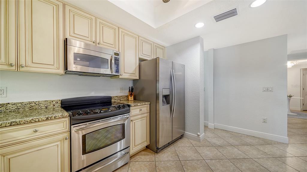 14041 Bellagio Way, Unit 316 Osprey, FL 34229 - Photo 24 of 74 a kitchen with granite countertop cabinets and steel stainless steel appliances