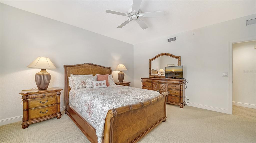 14041 Bellagio Way, Unit 316 Osprey, FL 34229 - Photo 37 of 74 a bedroom with a bed and dresser with mirror