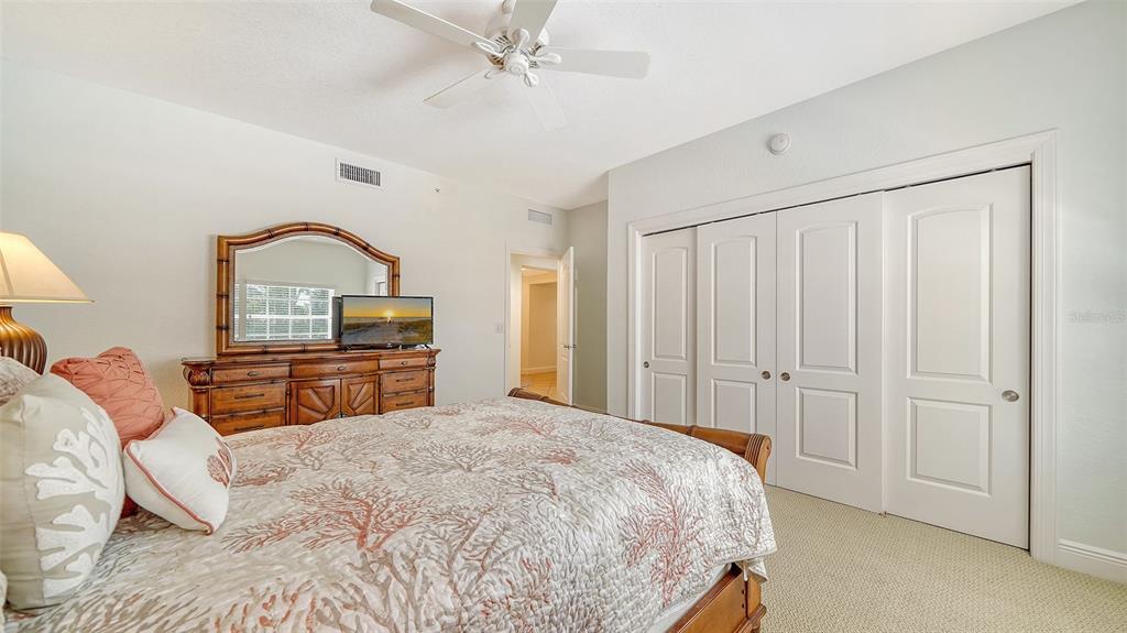 14041 Bellagio Way, Unit 316 Osprey, FL 34229 - Photo 38 of 74 a bedroom with a bed a dresser and potted plants