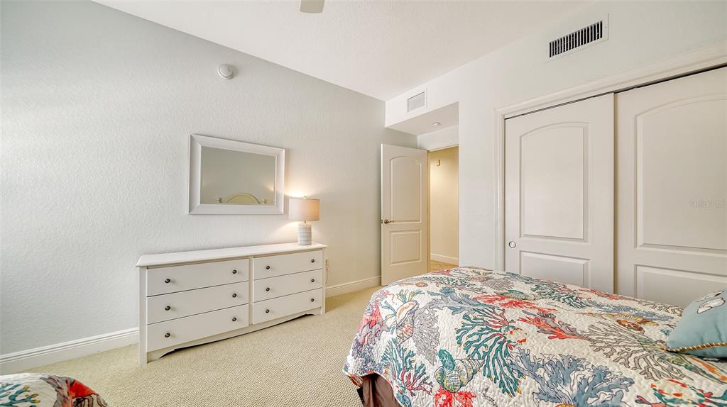 14041 Bellagio Way, Unit 316 Osprey, FL 34229 - Photo 42 of 74 a bedroom with a bed and a dresser in it