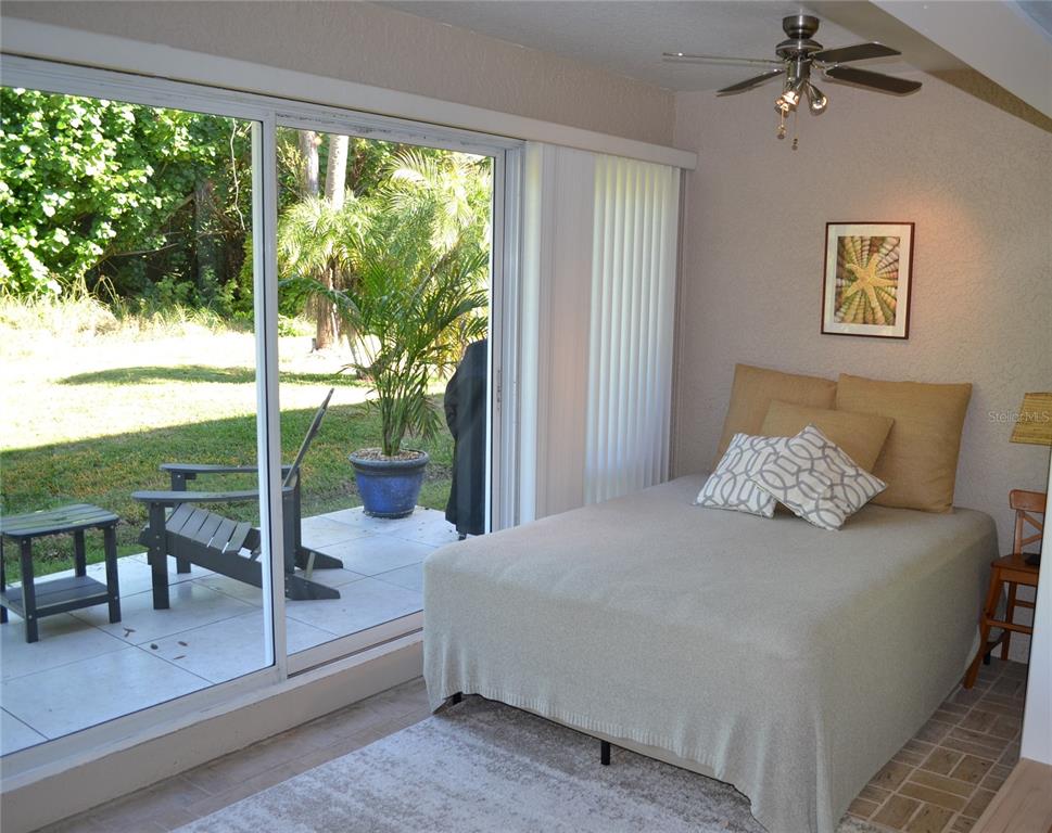 11158 Kapok Grand Circle Madeira Beach, FL 33708 - Photo 30 of 48 a spacious bedroom with a large bed and a balcony