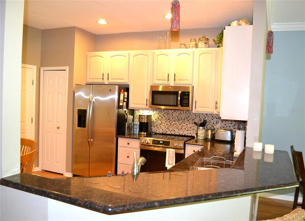 11158 Kapok Grand Circle Madeira Beach, FL 33708 - Photo 3 of 48 a kitchen with stainless steel appliances granite countertop a refrigerator and a stove