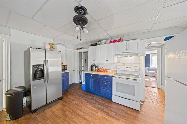 a kitchen with refrigerator cabinets and wooden floor