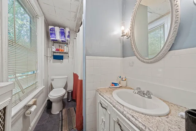 a bathroom with a sink toilet and a mirror