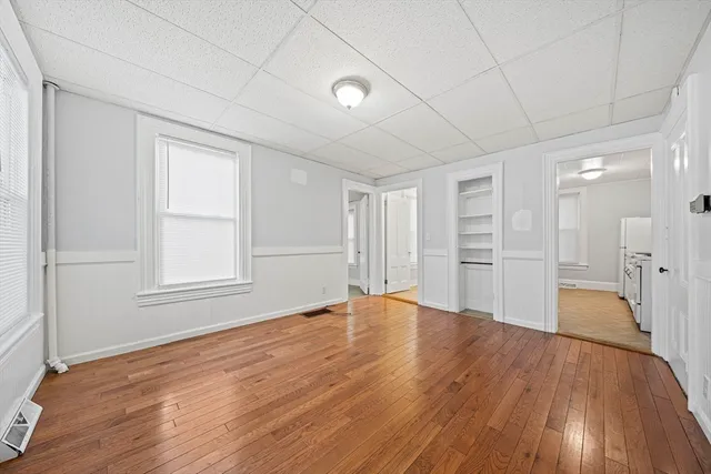 a view of empty room with wooden floor and window