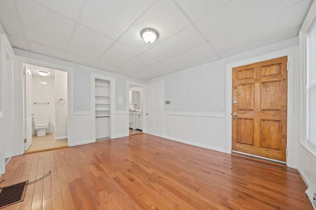 a view of empty room with wooden floor and entryway