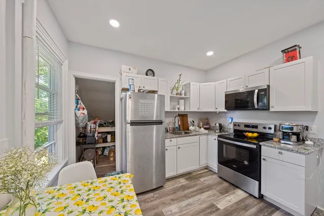 a kitchen with stainless steel appliances granite countertop a refrigerator and a stove top oven
