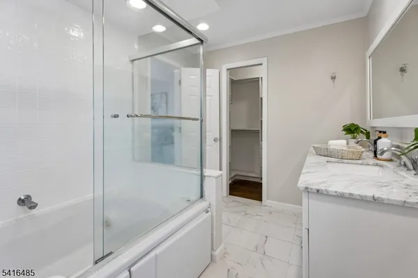 a bathroom with a granite countertop sink a mirror and shower