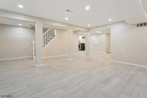 a view of a big room with wooden floor and windows