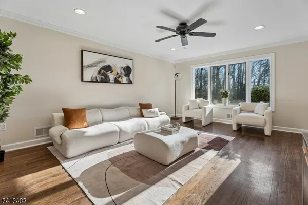 a living room with furniture and a large window with wooden floor
