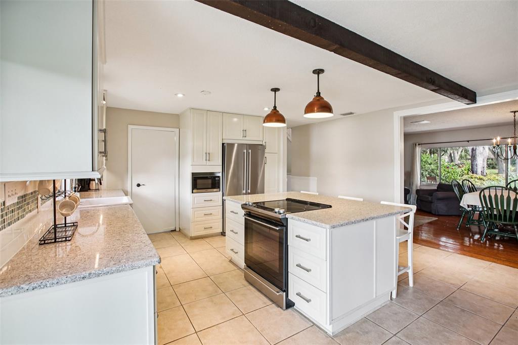 19254 Blount Road Lutz, FL 33558 - Photo 5 of 35 a kitchen with granite countertop a sink stove and refrigerator