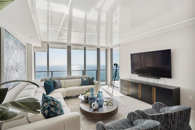 a living room with furniture a flat screen tv and a large window