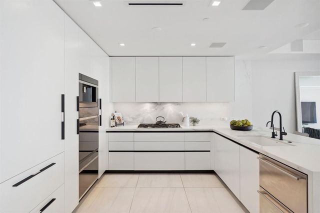 a kitchen with stainless steel appliances a sink and cabinets