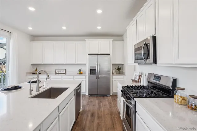 a kitchen that has a sink a stove and refrigerator