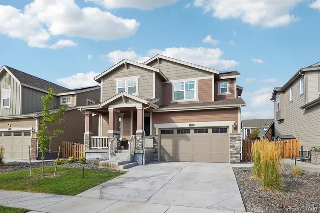 a front view of a house with a garden and plants