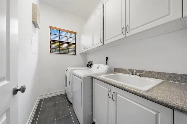 a utility room with sink dryer and washer
