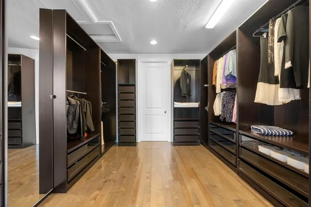 a view of a hallway with closet and wooden floor