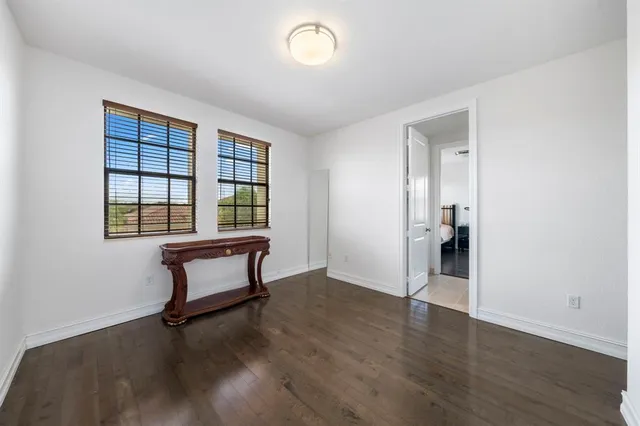an empty room with wooden floor a glass door and a window